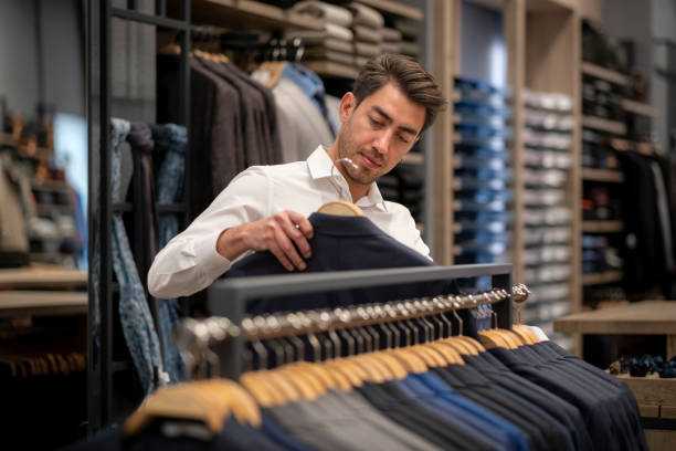 istock Handsome man is choosing clothes in the store 1456515282