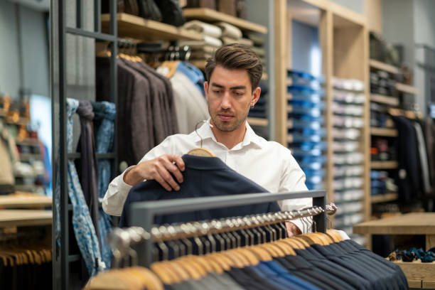 istock Handsome man is choosing clothes in the store 1456515283