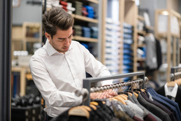 istock Handsome man is choosing clothes in the store 1456515291