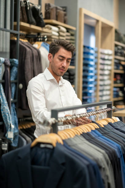 istock Handsome man is choosing clothes in the store 1456515308