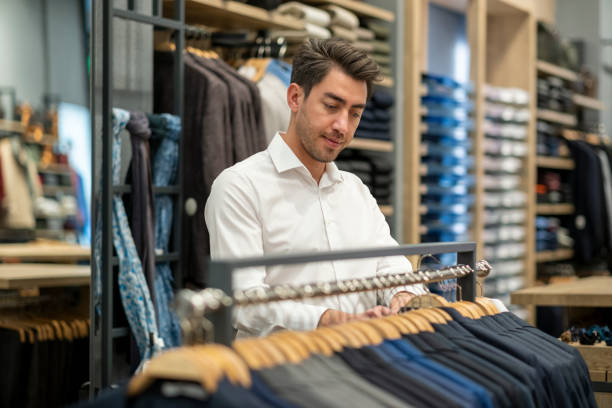 istock Handsome man is choosing clothes in the store 1456515309