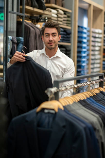 istock Handsome man is choosing clothes in the store 1456515320