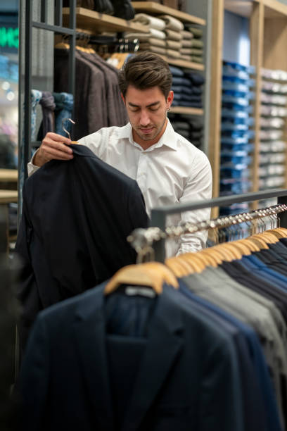 istock Handsome man is choosing clothes in the store 1456515321