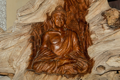 Close Up View Unique Carved Buddha Sitting Sculpture On A Wooden Block In A Room Of The Monastery