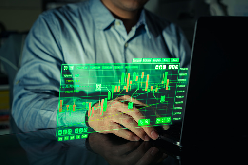 businessman use computer for investing in stock market techonology