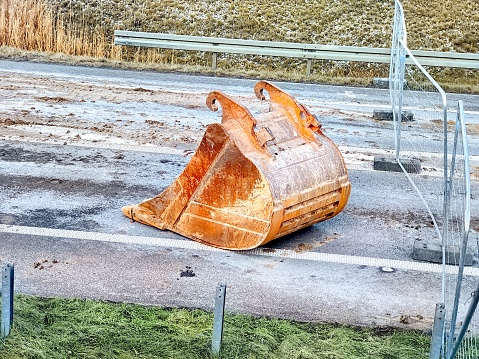 Excavator bucket lying on a road construction site