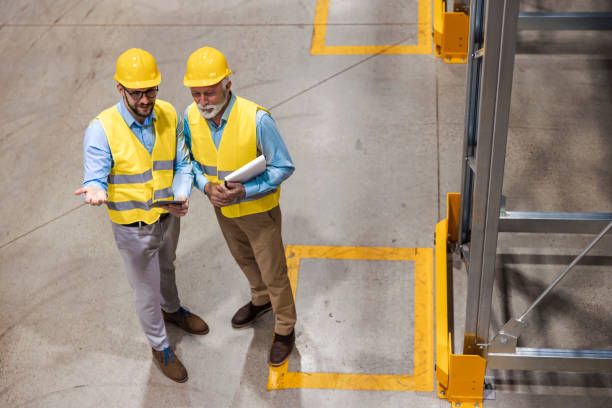 istock Two business people standing in warehouse and comparing data 1456526008