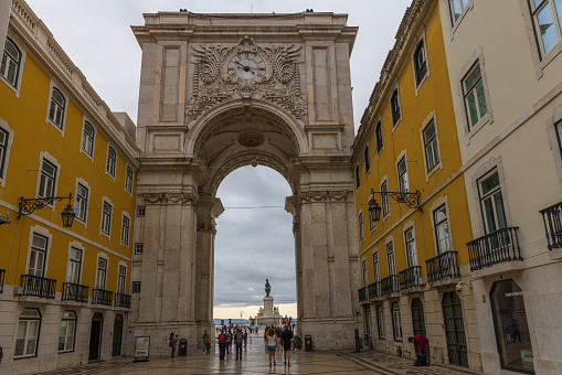 Lisbon, Portugal - October 16, 2022: The 19th century Rua Augusta Arch as seen from Rua Augusto street with the statue of King José I in the background