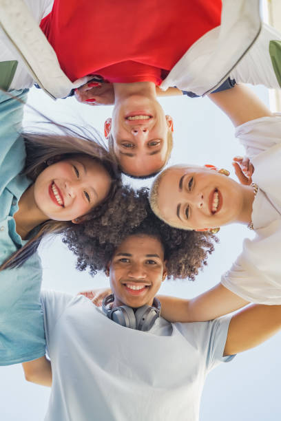istock Low angle view of multiethnic young trendy friends hugging. 1456531079
