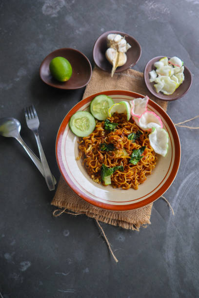 istock mie tek tek or fried noodle made with egg noodles with chicken, cabbage, mustard greens, meatballs, scrambled eggs. indonesian food 1456531457