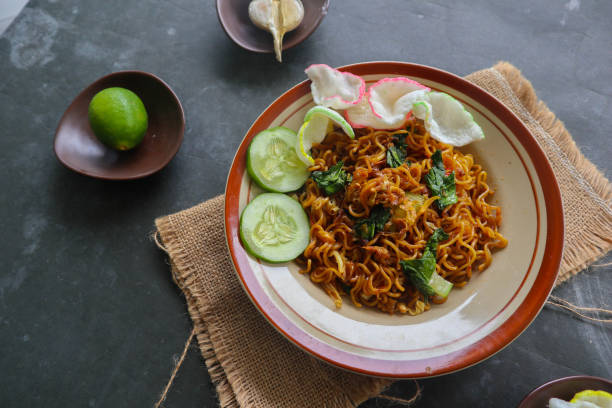 istock mie tek tek or fried noodle made with egg noodles with chicken, cabbage, mustard greens, meatballs, scrambled eggs. indonesian food 1456531494