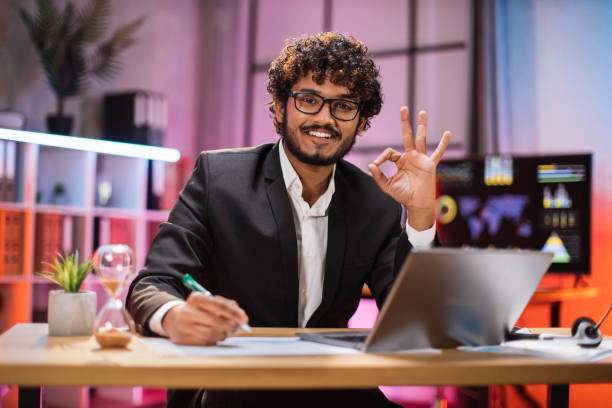 istock Portrait of attractive confident bearded IT specialist, office manager, wearing suit using laptop 1456531602