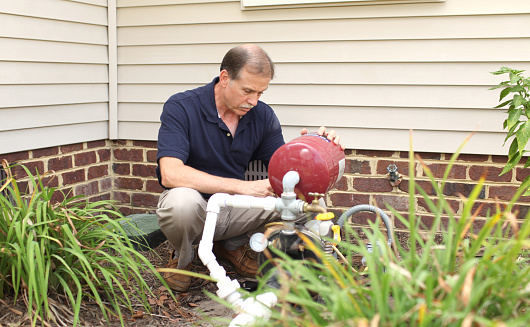 Senior male working on a well pump on his home