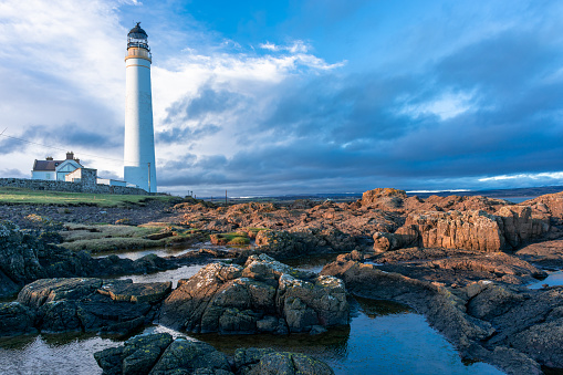 Lighthouse on the coast of the North Sea in Scotland against a dramatic sky