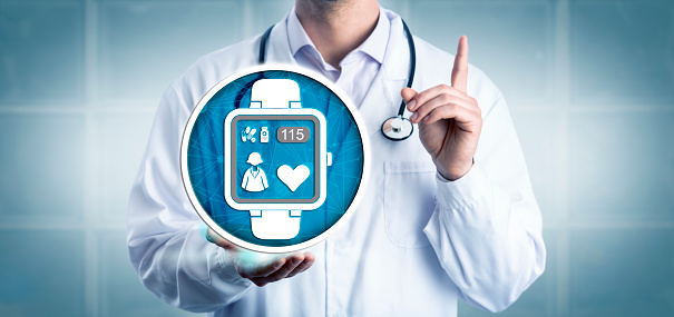 Unrecognizable clinician presenting a wearable medical device monitoring a patients heartbeat. Healthcare and medical technology metaphor for smart watch, remote monitoring of heart rate, IoMT.