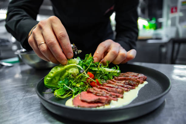 istock chef hand preparing Roastbeef salad with vegetables on restaurant kitchen 1456539842