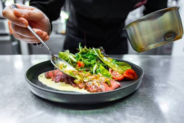 istock chef hand preparing Roastbeef salad with vegetables on restaurant kitchen 1456539851
