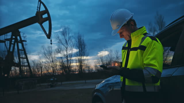 SLO MO Engineer uses a smartphone to enter data of the operation of a pumpjack