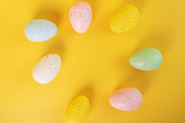 istock easter egg hunt, easter eggs of different colors on a yellow background 1456544705