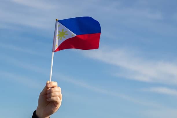 istock Philippines flag in hand flutters in the wind against the sky 1456544772