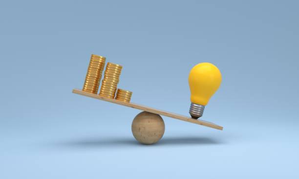 istock Coin stack compare light bulb idea on wood scale seesaw. Money gold coin compare balance with knowledge concept. 1456547849