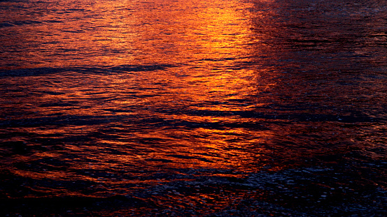 the reflection of the evening light on the surface of the sea water on the beach