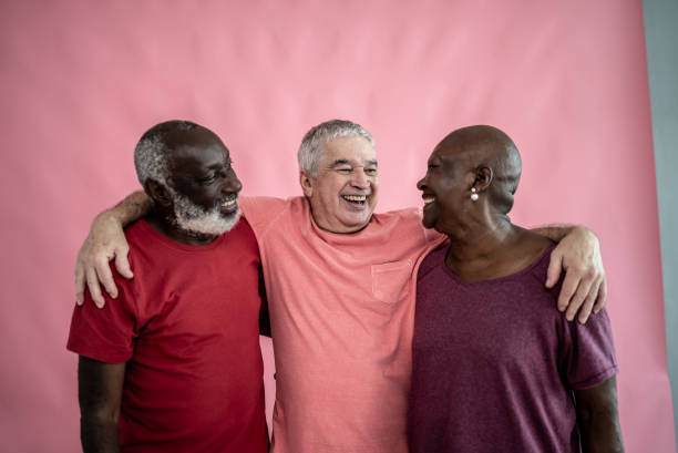 istock Senior friends embracing on a pink background 1456549093