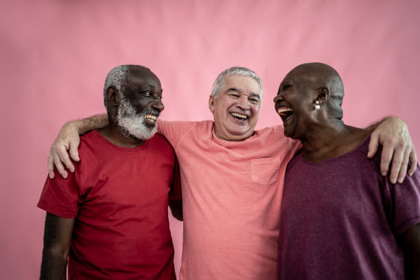 istock Senior friends embracing on a pink background 1456549094