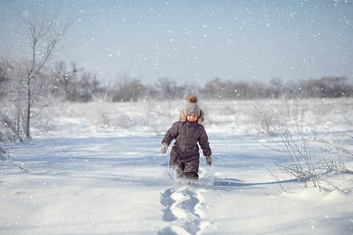 preschool boy running through snowdrifts