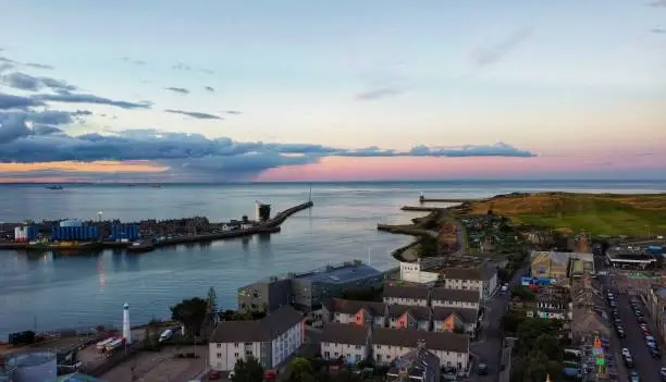 Aberdeen Harbour & The Port of Aberdeen and the surrounding area of Torry, St Fitticks park, Balnagask golf club & Greyhope bay during a pink sunset.