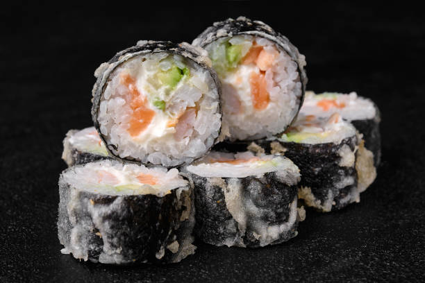 istock baked sushi rolls with salmon on black concrete background 1456551819