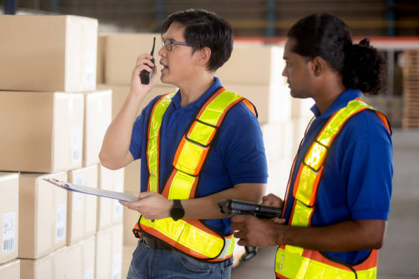 istock Supervisor young man standing using radio talking for instruction and planning while worker inspector cargo at distribution warehouse, logistic and depot for transportation, shipping and shipment. 1456554966