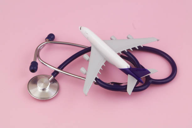 istock Airplane model and stethoscope on pink background 1456557593