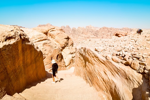 Turista caucásica parada en la escalera al monasterio de A'dir en la montaña en Petra monumento histórico de la ciudad perdida photo