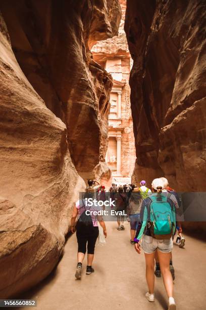 Tourists Walk Towards Treasury Landmark In Petra Through The Siq The Narrow Slotcanyon That Serves As The Entrance Passage To The Hidden City Of Petra Jordan Stock Photo - Download Image Now