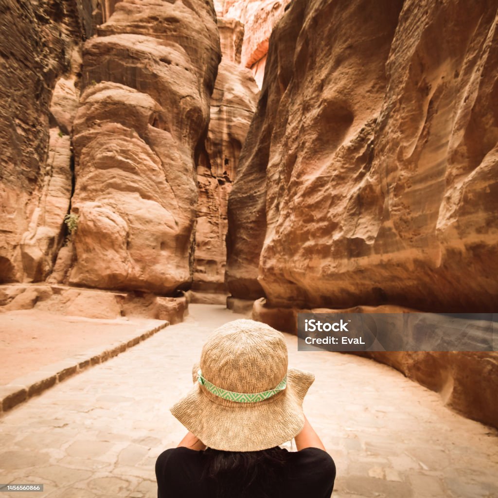 Tourist in Petra take photograph of The Siq, the narrow slot-canyon that serves as the entrance passage to the hidden city of Petra, Jordan 35-39 Years Stock Photo
