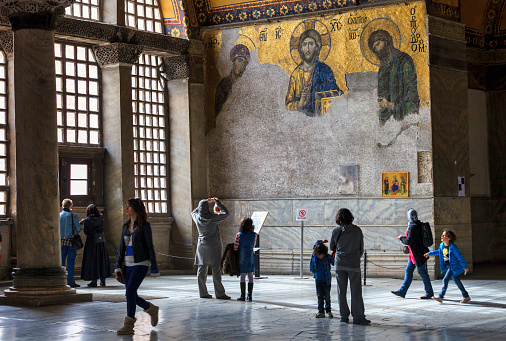 Istanbul,Turkey-Mar 08,2013:Mosaic of Jesus Christ in the old church of Hagia Sophia in Istanbul, Turkey and the follower tourists.Museum of Hagia Sofia is one of the greatest examples of Byzantine architecture and mostly visited landmark by tourists in Istanbul.
