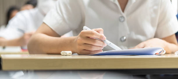 istock Exam at school with student's taking educational admission test in class, thinking hard, writing answer in university classroom, education and world literacy day concept 1456565604