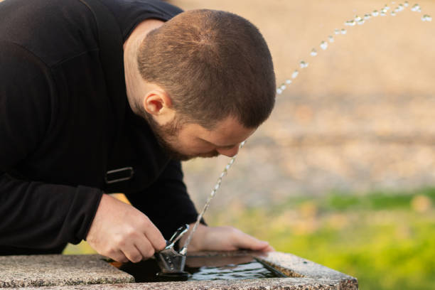 istock man drinking water from a drinking fountain in the park 1456570258