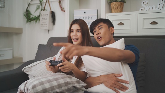 Happy young couple playing video games.