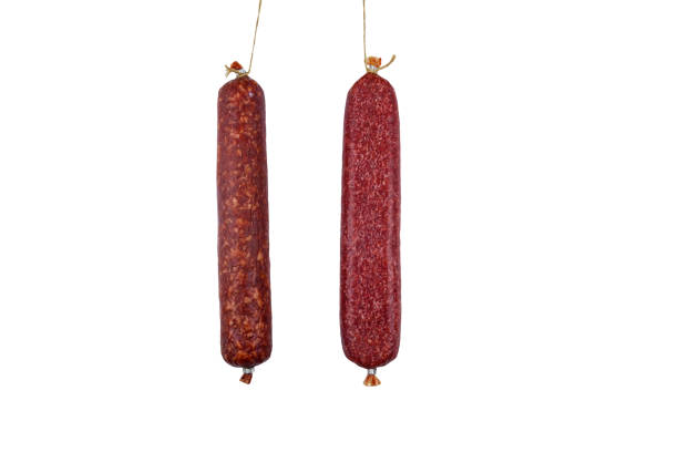 Two hanging raw smoked sausage isolated on white background