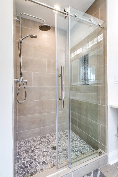 istock A shower with a stone floor and brown tiled walls. 1456571215
