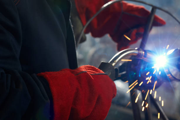 Close-up of a welder at a factory making metal structures. stock photo