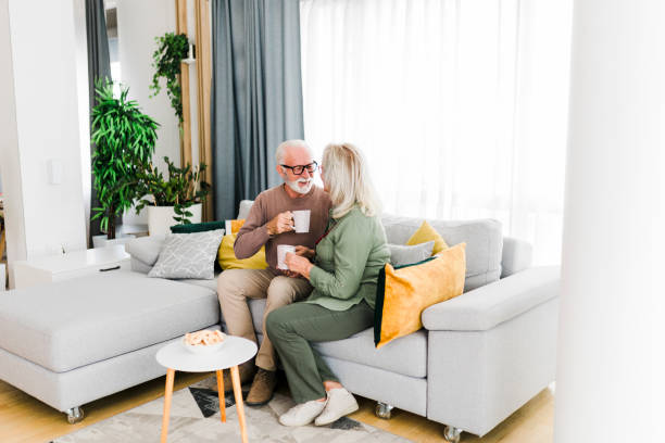 istock Senior retired couple drinking tea and enjoy talking conversation together on sofa with happiness laugh smile and joyful at home 1456573583