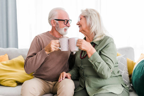 istock Senior retired couple drinking tea and enjoy talking conversation together on sofa with happiness laugh smile and joyful at home 1456573621