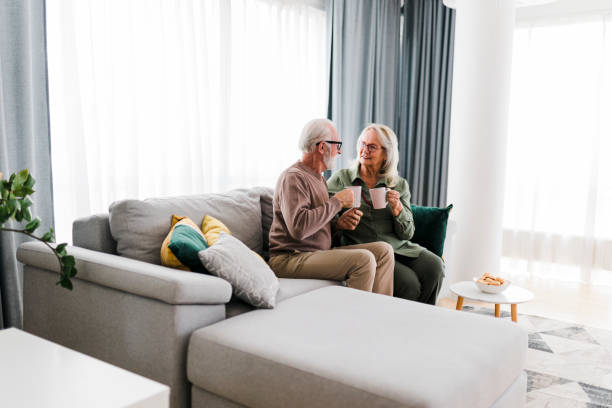 istock Senior retired couple drinking tea and enjoy talking conversation together on sofa with happiness laugh smile and joyful at home 1456573650