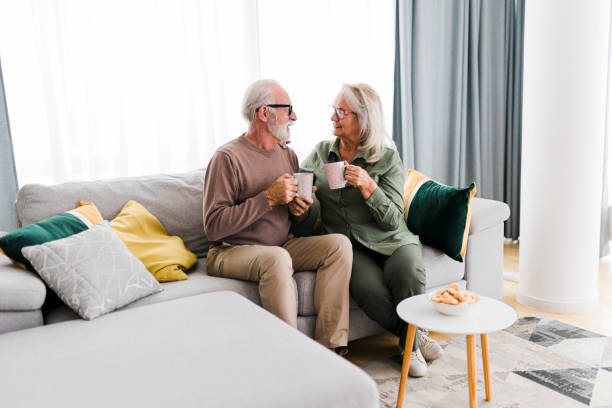 istock Senior retired couple drinking tea and enjoy talking conversation together on sofa with happiness laugh smile and joyful at home 1456576083