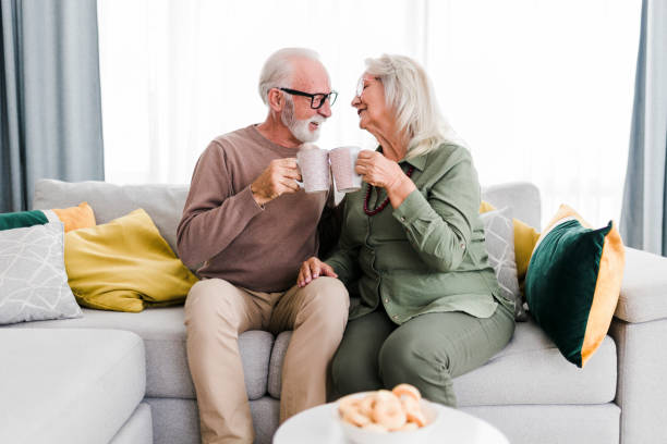 istock Senior retired couple drinking tea and enjoy talking conversation together on sofa with happiness laugh smile and joyful at home 1456576097