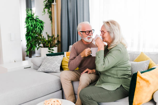 istock Senior retired couple drinking tea and enjoy talking conversation together on sofa with happiness laugh smile and joyful at home 1456576111