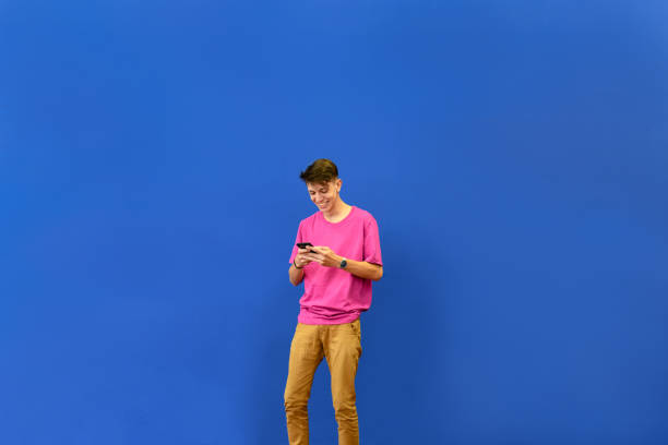 Young man having fun looking at his cell phone stock photo